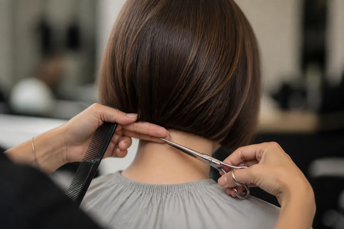 Nuque dégagée d’un carré plongeant court vue de dos dans un salon
