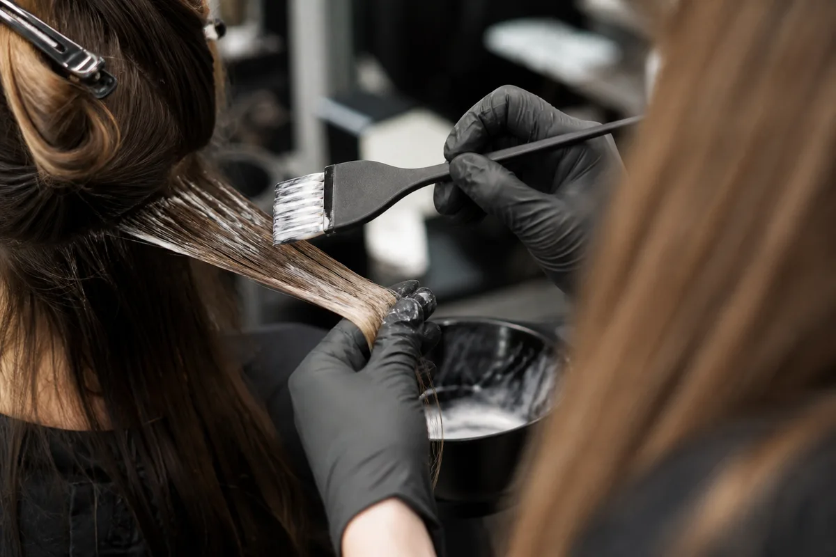 Coiffeuse en plein travail de coloration dans un salon lumineux